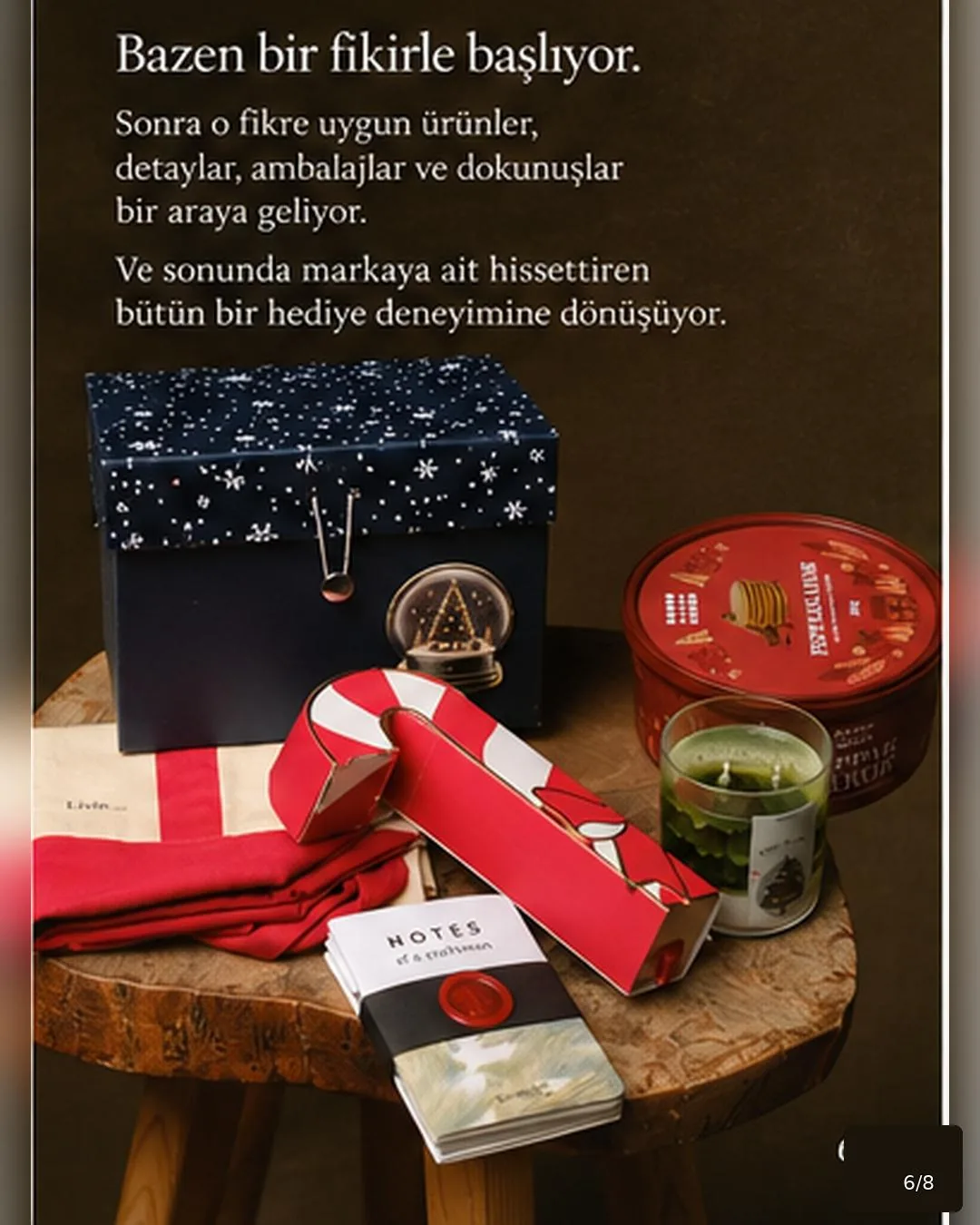 Lacivert hediye kutusu, kırmızı şerit, mum ve not defterinden oluşan kurumsal hediye seti
